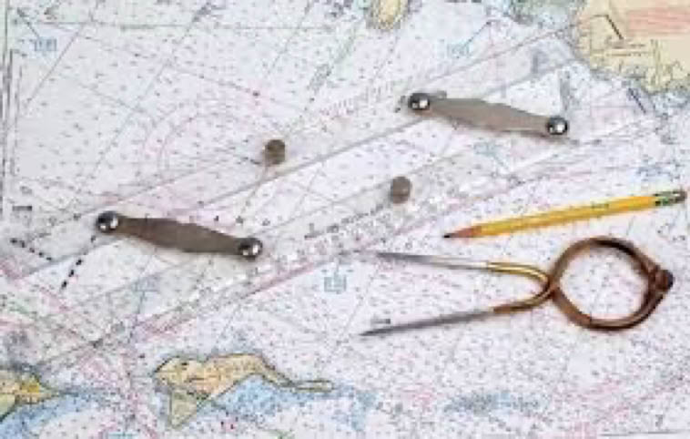 A nautical chart with parallel rulers, a pencil, and a pair of dividers placed on top.